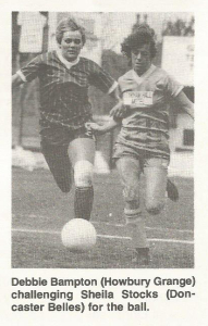A black and white photo of two women footballers running after a ball
