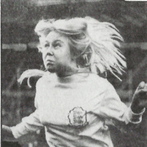 woman with long blonde hair jumping for a football