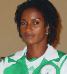 A woman of colour smiling enigmatically and wearing a green and white tracksuit